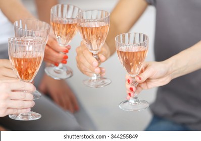 Friends hands with glasses of pink wine, close up