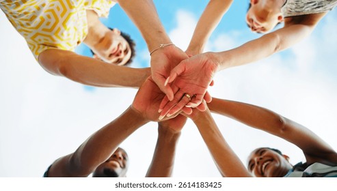 Friends, hands stack and low angle with sky, smile and support with motivation, diversity and cheers. People, group and happy with celebration, reunion and excited in nature, outdoor and vacation