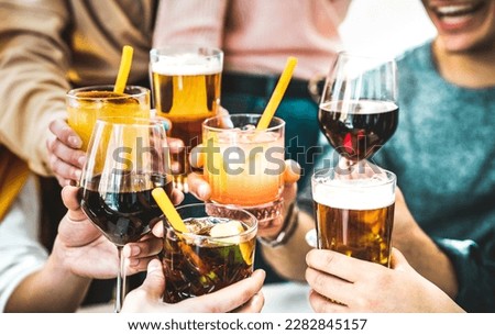 Friends hands toasting fancy cocktails - Young people having fun together drinking beer and wine at happy hour - Social life style party time concept on vivid filter - Focus on lower cuba libre drink