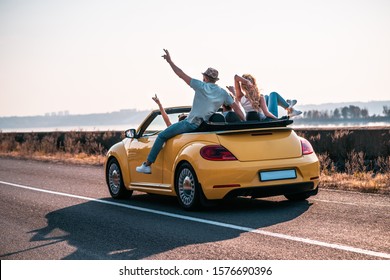 The friends have fun traveling by a cabriolet - Powered by Shutterstock