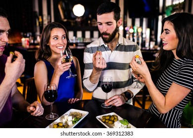 Friends having an aperitif with wine in a bar