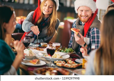 Friends Having Dinner At Home At Christmas Eve. Winter Holidays Concept.