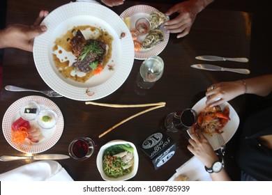 Friends Having A Dinner Party. Different Dishes On The Restaurant Table, Top View
