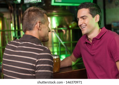 Friends Having Fun At Bar. Two Cheerful Male Friends Talking At Bar And Drinking Beer