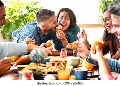 Friends having fun at breakfast and eating muffins at bakery or pastry shop - Beautiful happy couple eating cupcake with whipped cream in a cafe - Young woman is feeding her boyfriend - Powered by Shutterstock