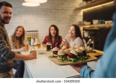 Friends having fun, drinking beer and eating hamburgers. - Powered by Shutterstock