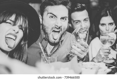 Friends having fun drinking cocktails and taking selfie in the bar - Young people taking photo in the club making silly faces - Concept of friendship, lifestyle, nightlife - Focus on man on left  - Powered by Shutterstock