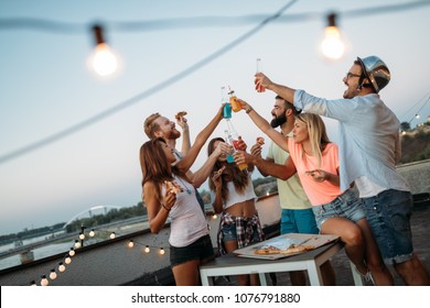 Friends Having Fun And Drinking Outdoor On A Rooftop Get Together