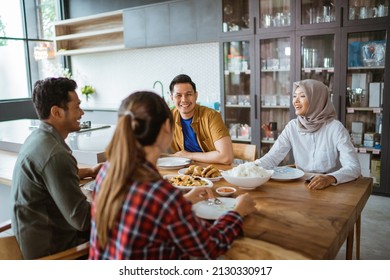 Friends Having Fun Eating Lunch Together At Home With Traditional Food