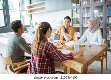 Friends Having Fun Eating Lunch Together At Home With Traditional Food