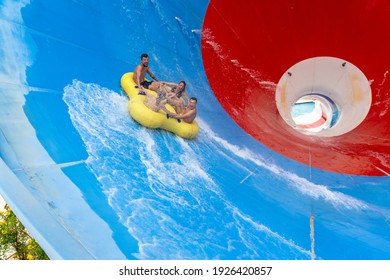 Friends Having Fun Sliding In A Big Water Slide