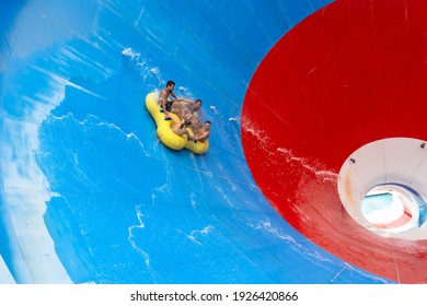 Friends Having Fun Sliding In A Big Water Slide