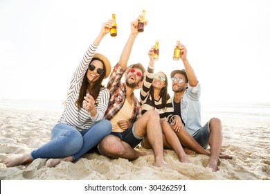 Friends Having Fun Together At The Beach And Drinking A Cold Beer