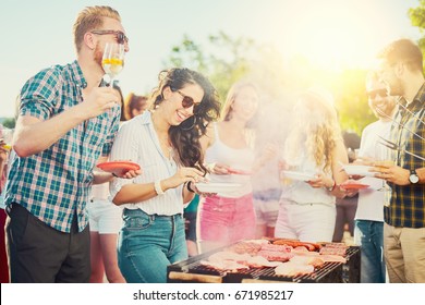 Friends having outdoor party and eating barbecue - Shutterstock ID 671985217