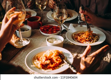 Friends having a pasta dinner at home of at a restaurant.