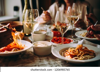 Friends having a pasta dinner at home of at a restaurant. - Shutterstock ID 1206985765