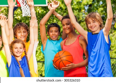 Friends hold arms up at basketball game
