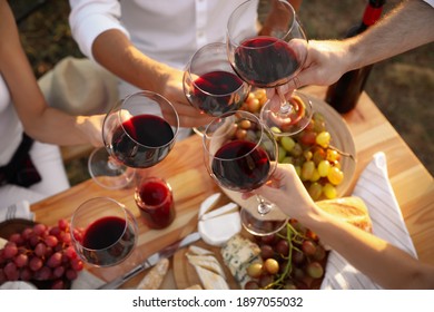 Friends holding glasses of wine at table, closeup - Powered by Shutterstock