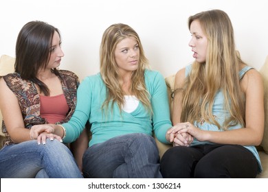 Friends Holding Hands Complaining While Sitting On A Couch