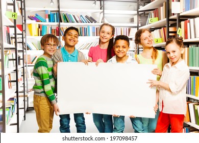 Friends Holding White Paper Sheet In Library