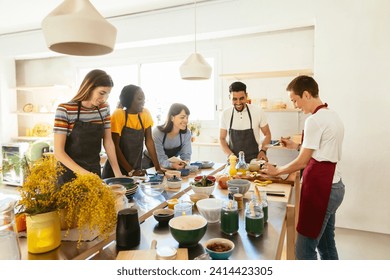 Friends and instructor in a cooking workshop preparing food - Powered by Shutterstock