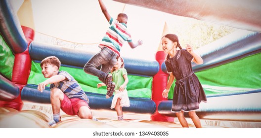 Friends jumping on bouncy castle at playground - Shutterstock ID 1349403035