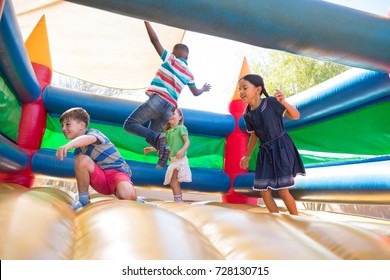 Friends jumping on bouncy castle at playground - Shutterstock ID 728130715