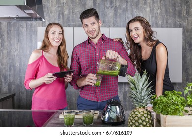 friends in the kitchen preparing a green tasty healthy drink made of vegetables and herbs - Powered by Shutterstock