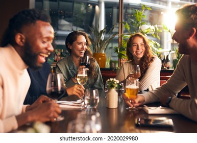 Friends laughing with drinks in bar - Powered by Shutterstock