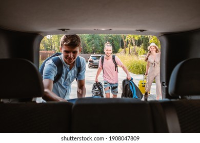 Friends Load Car Trunk With Baggage. Summer Road Trip Vacation.