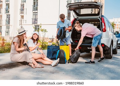 Friends Load Car Trunk With Baggage. Summer Road Trip Vacation.