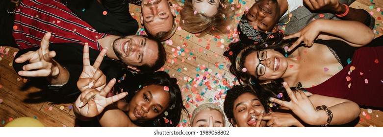 Friends lying on the floor at a party with balloons
