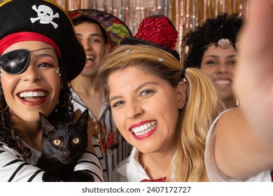 Friends make self-portraits with Brazilian carnival costumes. Pirate woman holds a black cat. Group of brazilian friends partying in a nightclub.