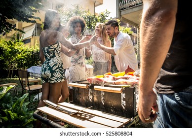 Friends making barbecue in the garden