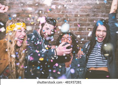 Friends making big party in the night. Four people throwing confetti and drinking champagne - Shutterstock ID 481937281
