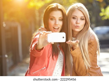 Friends making selfie. Two beautiful young women making selfie - Powered by Shutterstock