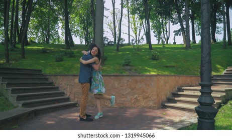 Friends meeting in the park. Handsome man and attractive woman happy to meet. Beautiful caucasian female smile to hipster guy. joyful meeting friendly hug outdoors in summer.