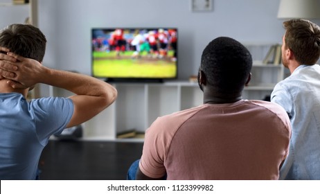 Friends Nervously Watching American Football Competition On Screen, Sofa Experts