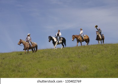 Friends On A Horseback Trail Ride Against A Blue Sky