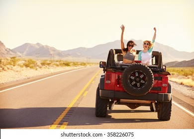 Friends On Road Trip Driving In Convertible Car
