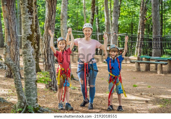 Friends on the ropes course. Young people in safety\
equipment are obstacles on the road rope Portrait of a disgruntled\
girl sitting at a cafe\
table