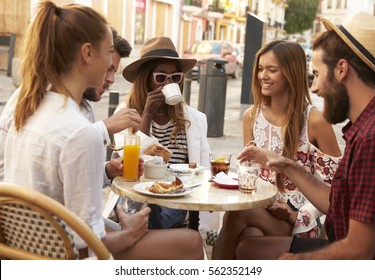 Friends On Vacation At A Table Outside A Cafe In Ibiza