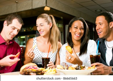 Friends - One Couple Is African American - Eating Hamburger And Drinking Soda In A Fast Food Diner; Focus On The Meal