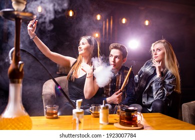Friends party in hookah lounge smoking shisha night time