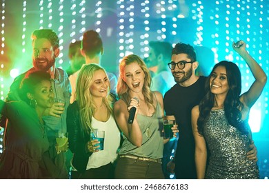 Friends, people and singing in nightclub together, night life and fun for celebration or new years party or karaoke. Festival, disco lights and social or dancing with microphone, enjoy and happy - Powered by Shutterstock