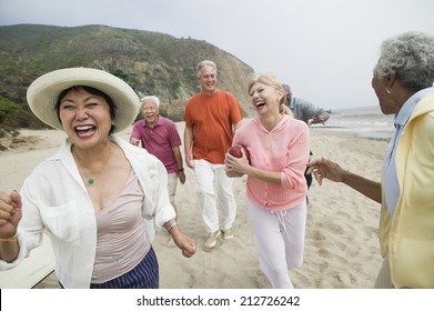 Friends playing american football on beach - Powered by Shutterstock