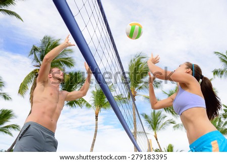 Friends playing beach volleyball sport. Woman and man having fun recreational volley ball game in summer living healthy active sport lifestyle.