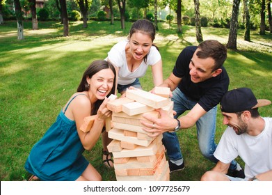 Friends playing board game outdoors.