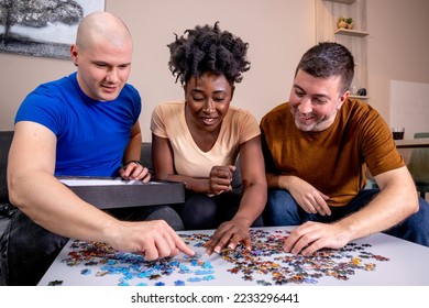 Friends playing with jigsaw puzzle at home, on a white wooden table. Putting things together and solving problems. Fun and diversity in friendship. - Shutterstock ID 2233296441