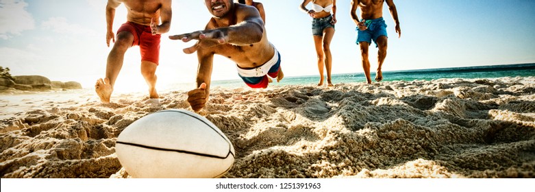 Friends playing rugby at the beach - Powered by Shutterstock